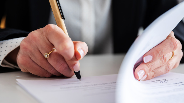 Woman's hand signing legal papers