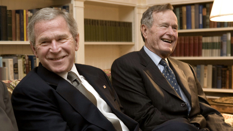 George W. Bush and George H.W. Bush sitting side by side.