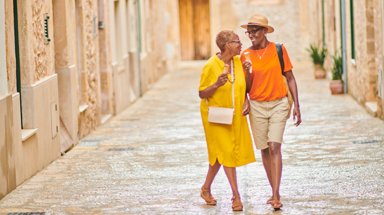 Couple walking down cobblestone street