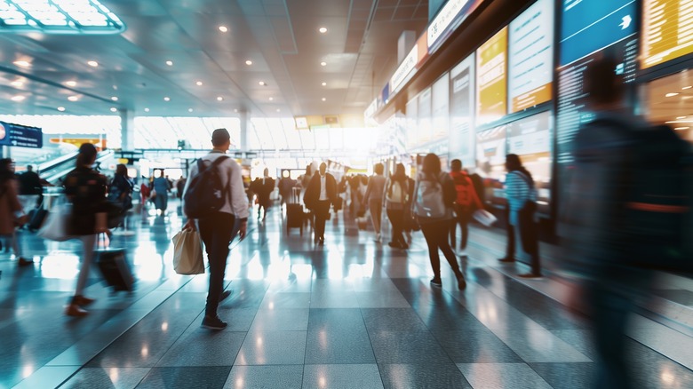 People walking through busy airport terminal