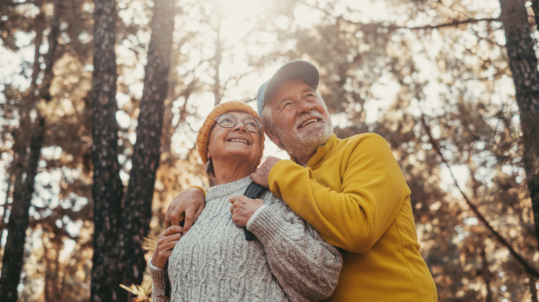 Active senior couple on a walk in a beautiful autumn nature.