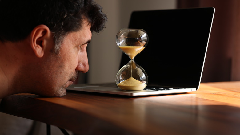 Man watching sand fall in hourglass