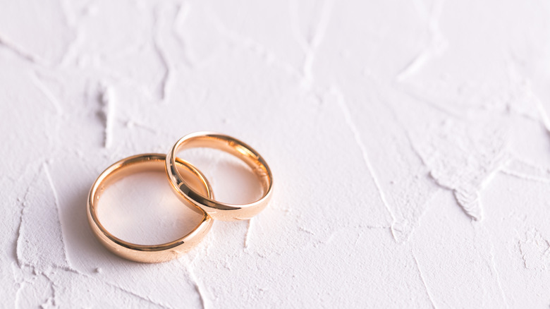 Two gold wedding rings with a white background