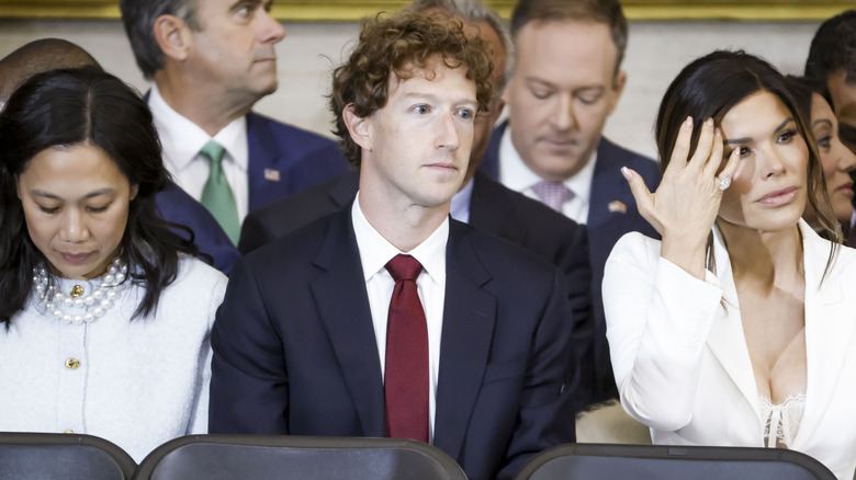 Suited Mark Zuckerberg between his wife Priscilla Chan and Lauren Sanchez at Inauguration