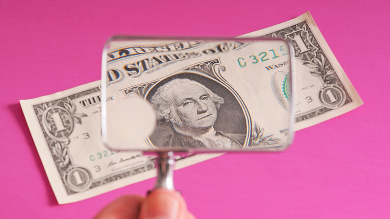 Looking at a dollar bill with a magnifying glass