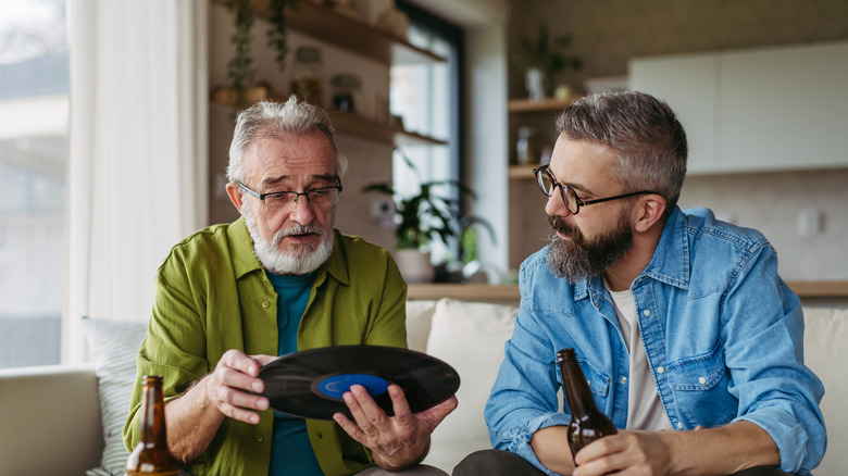 Two men with beards and glasses analyze a vinyl record