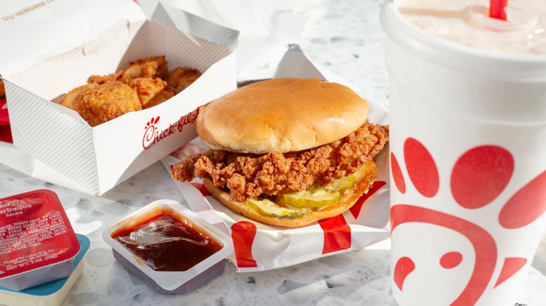 a Chick-fil-A sandwich, fried chicken, sauces, and drink