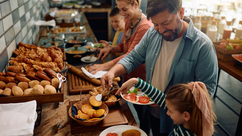 A family selecting items from a breakfast buffet
