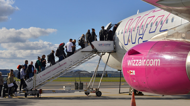 Passengers climb into a Wizz airliner at Warsaw Chopin Airport
