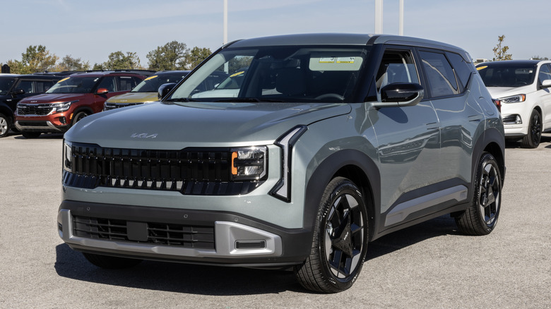 A silver 2027 Kia Seltos parked in front of a line of other SUVs