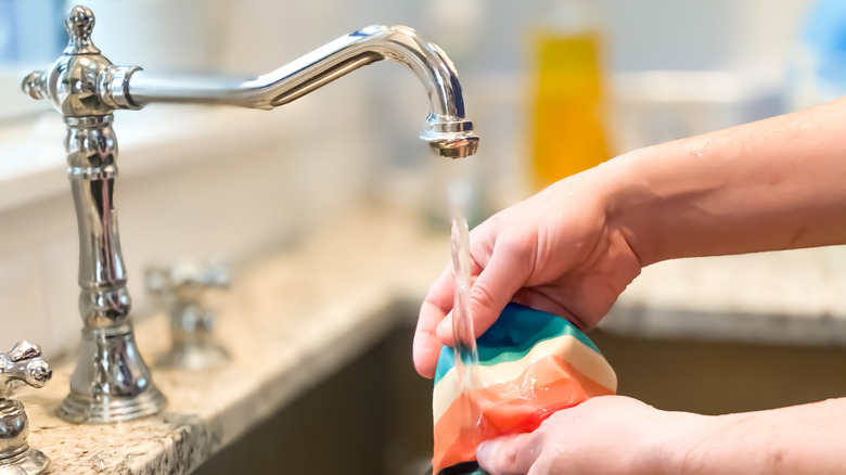 A person washing a clothing item in a sink