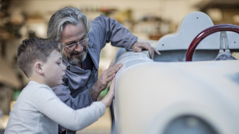 Man and boy looking at car