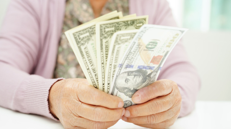 Close up of hands holding cash.