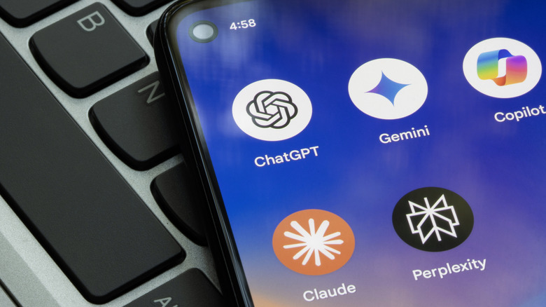 Multiple AI apps shown on a smartphone on top of a laptop keyboard
