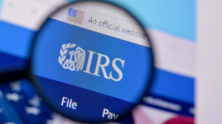 Magnifying glass zooming in on the IRS logo on a computer screen