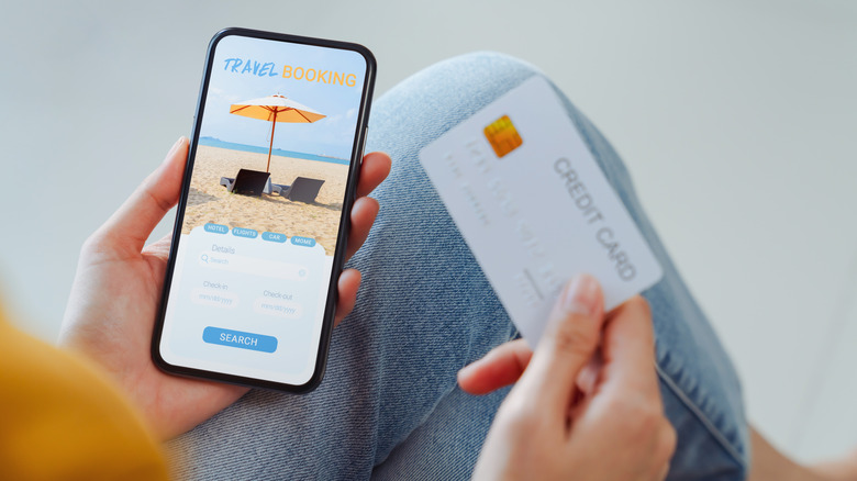 Person booking vacation with credit card.