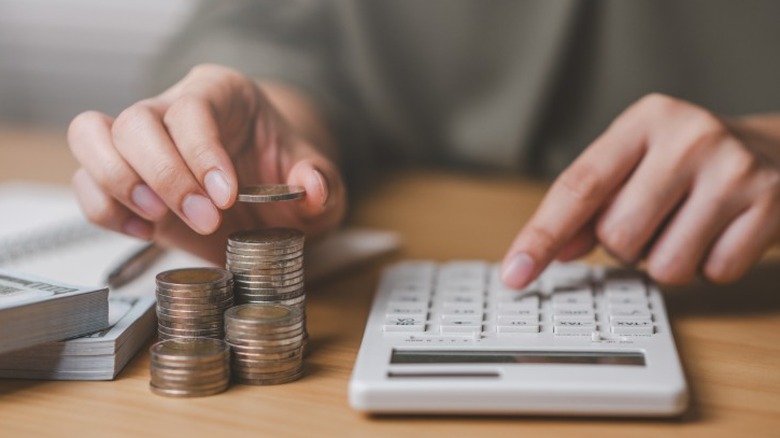 A person adding up money on a calculator.