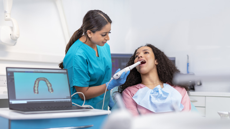 Dentist using scanner inside patient's mouth