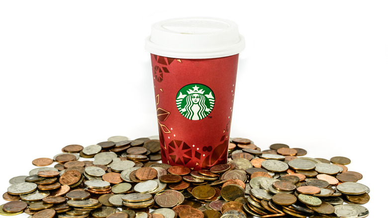 Starbucks cup surrounded by coins