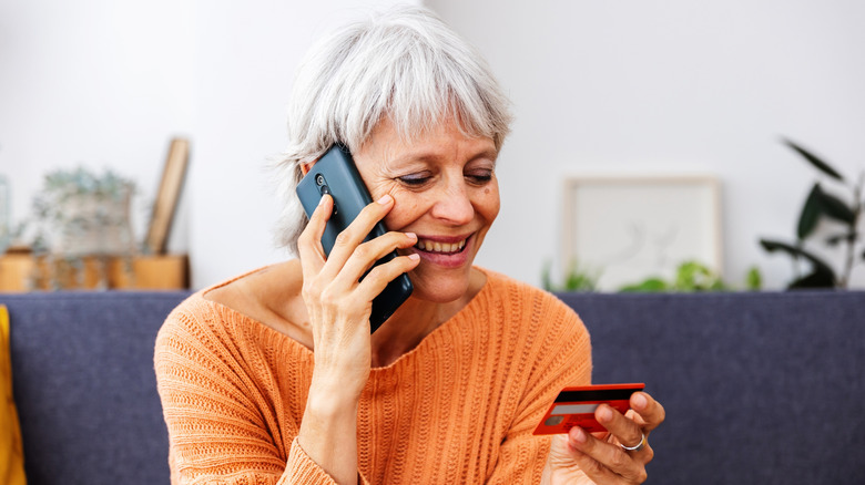 Baby boomer making a purchase over the phone with credit card.