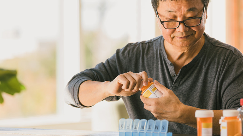 Man sorting his daily prescription drugs