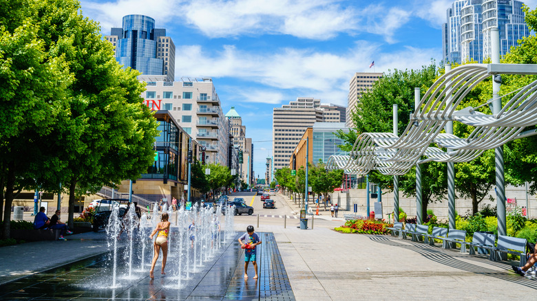 Children playing in a public fountain with downtown Cincinnati in the backdrop.