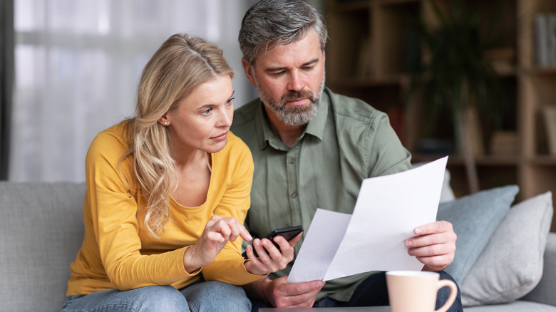 People quizzically looking at papers