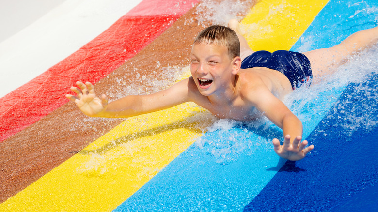 Boy riding a multicolor water slide