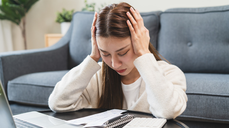 A young woman looking confused as she pays taxes