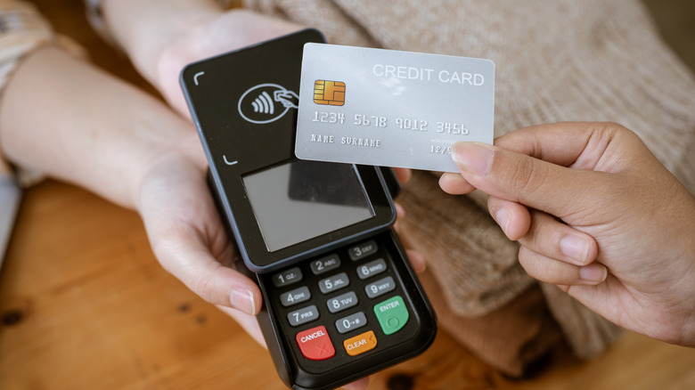 Consumer tapping her credit card on payment terminal