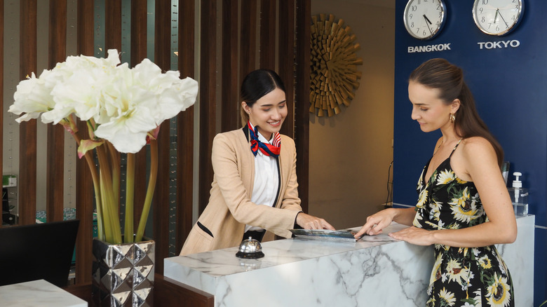 A woman at front desk checking in to a hotel