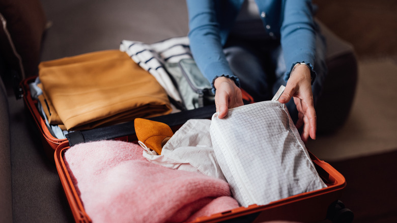 person packing a suitcase
