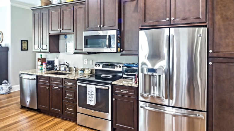 Kitchen with dark wood cabinets, granite countertops, and matching stainless-steel appliances