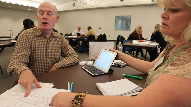 Woman and elderly man discussing insurance options