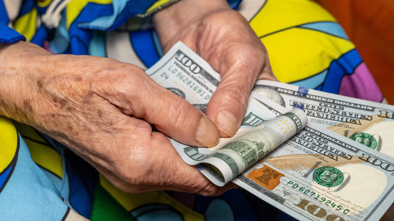 Older woman's hands holding cash
