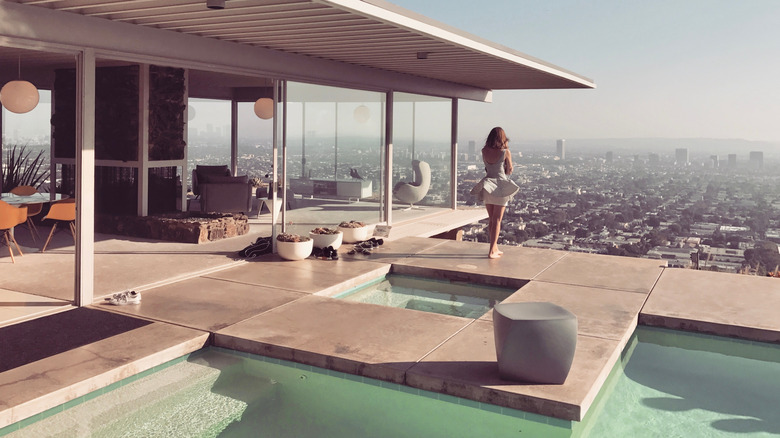 The iconic Stahl House with a view of pool and glass walls, and the city in the haze in the background