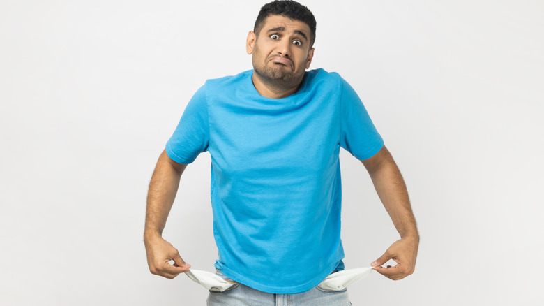 man showing empty pockets