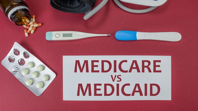 Words Medicare vs Medicaid in white square on top of red background with pills, themometor, and pregnacy test