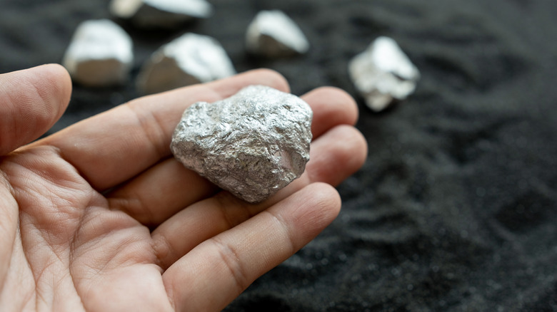 hand holding silver metal chunk