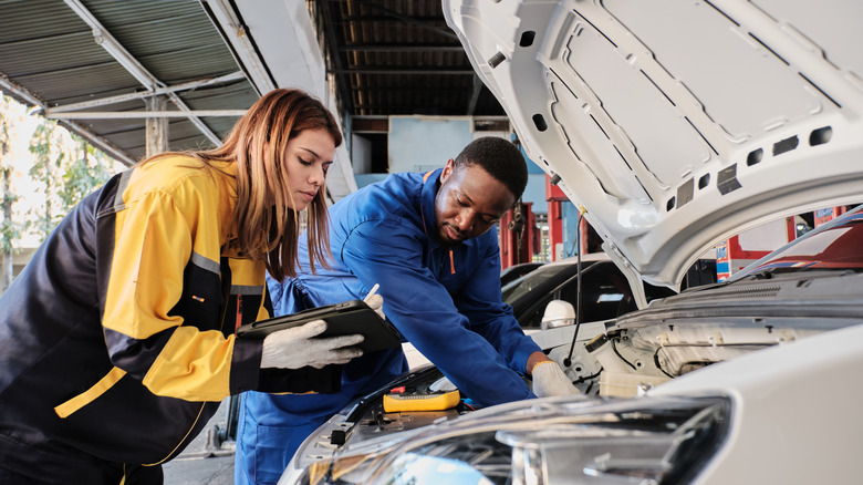 Two people working on a EV