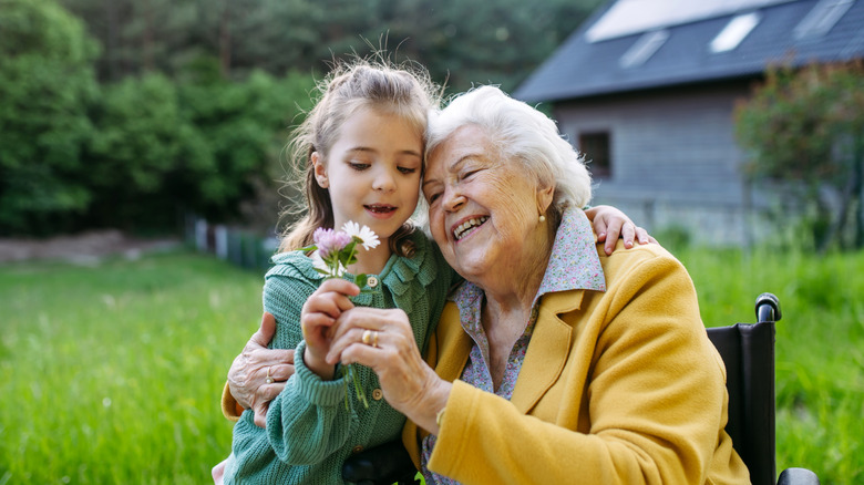 A senior and a child sitting outside