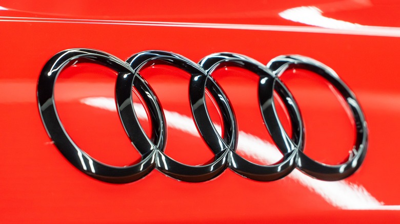 Audi logo on the trunk lid of the red car.
