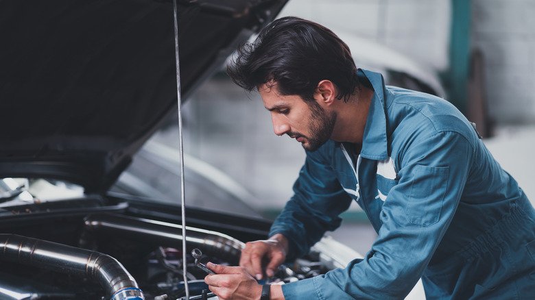 A mechanic is repairing a car in the garage