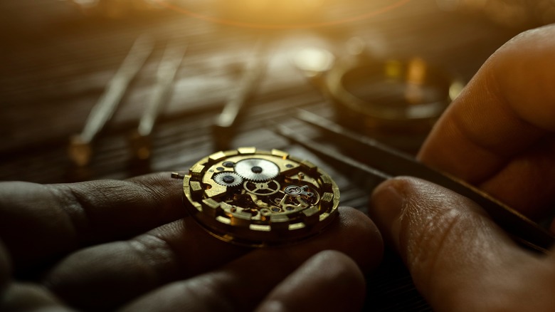Watch maker assembles watch movement.