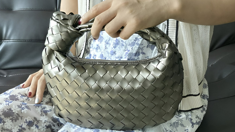 A person holding the Gomayee Knotted Woven Handbag for Women
