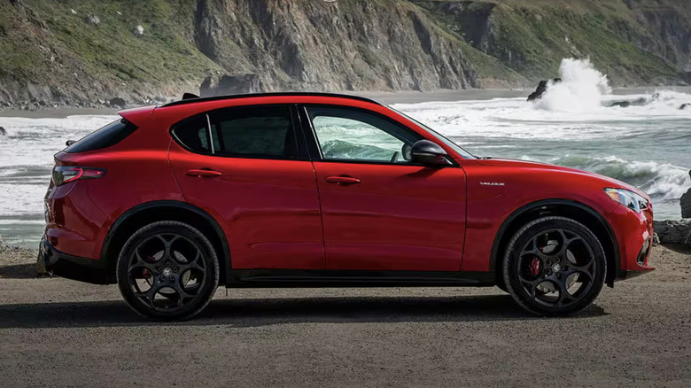 A red Alfa Romeo Stelvio SUV parked at the beach