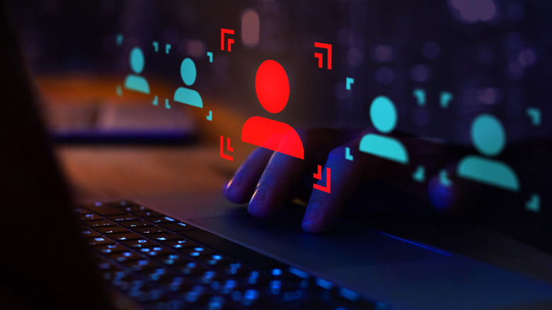 A hand on a dark laptop computer, underneath a red "error" log-in icon