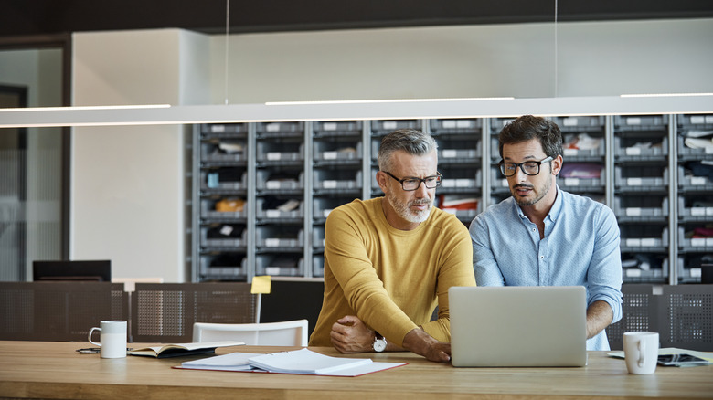 Two men on laptops at work
