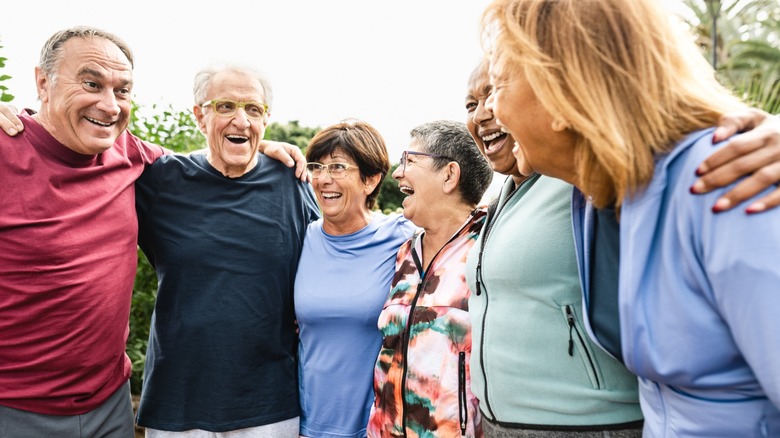 A diverse group of seniors embracing each other