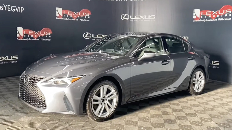 Sunlight shines on a 2022 Silver Lexus IS 300 in a show room with a checkered floor